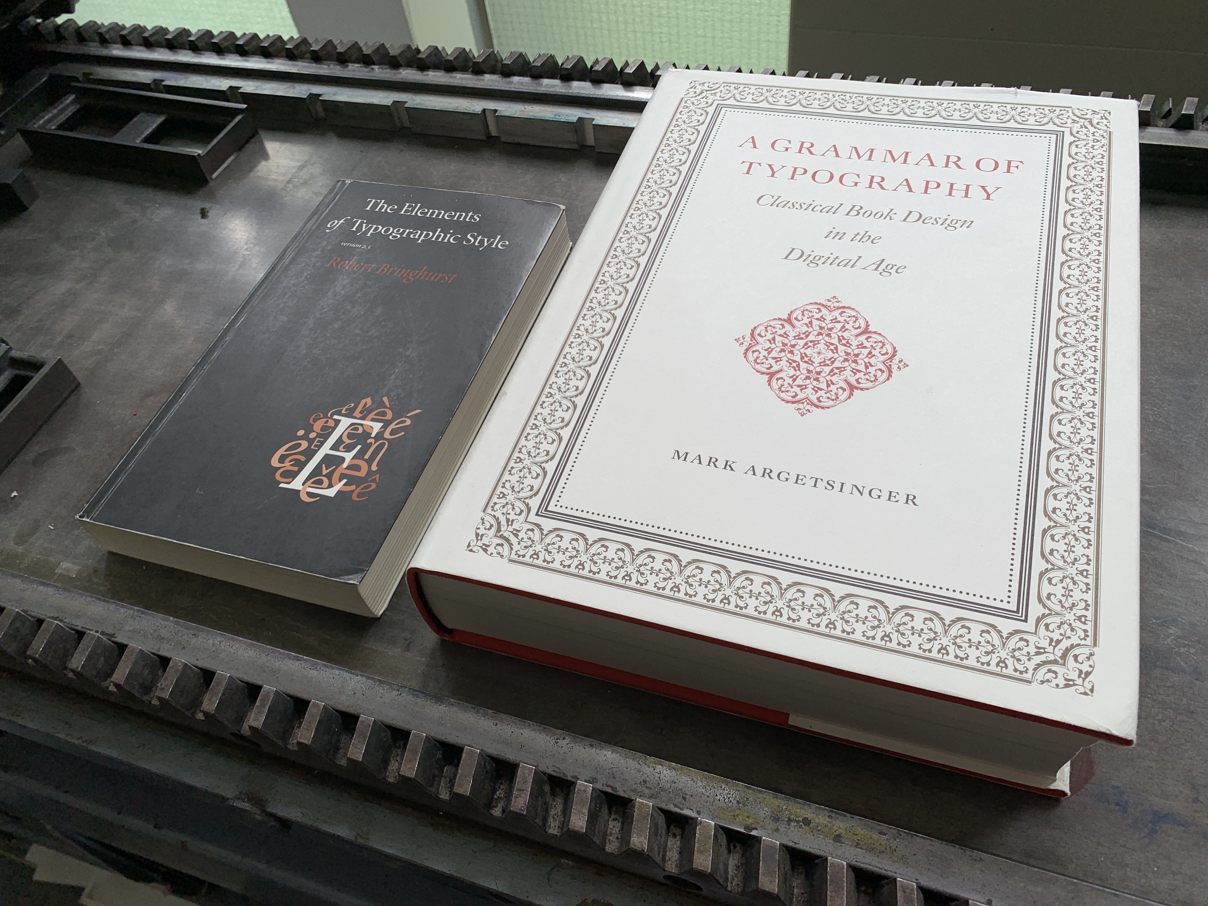 Photograph of Robert Bringhurst’s book The Elements of Typographic Style and Mark Argetsinger’s  Grammar of Typography: Classical Book Design in the Digital Age on a proofing press in Krefeld